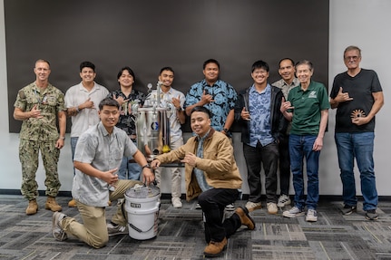 Capt. Ryan McCrillis, commander of the Pearl Harbor Naval Shipyard and Intermediate Maintenance Facility, poses with University of Hawaii Manoa students following their final presentations on Dec. 5, 2025.