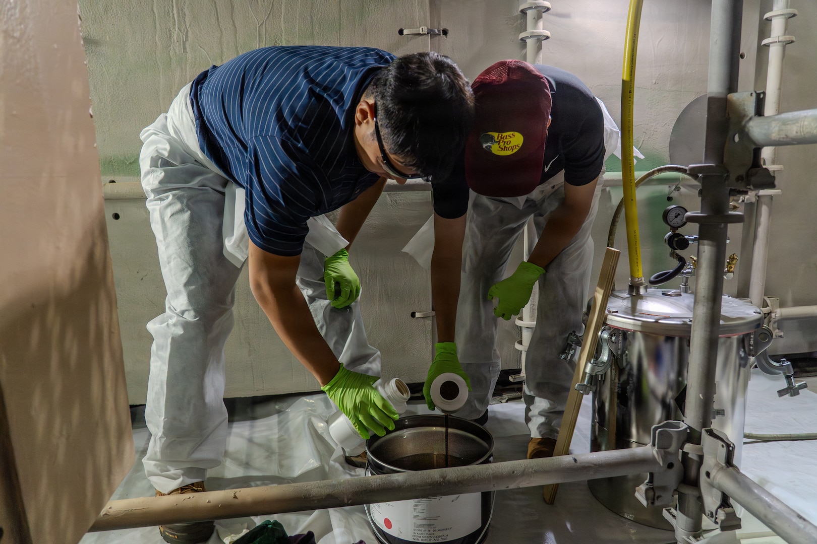 Kody Miyamoto and King Joash (KJ) Rumbaoa, University of Hawaii Manoa students, prepare a two-part Versathane resin for application on Oct. 24, 2025.