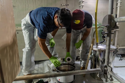 Kody Miyamoto and King Joash (KJ) Rumbaoa, University of Hawaii Manoa students, prepare a two-part Versathane resin for application on Oct. 24, 2025.