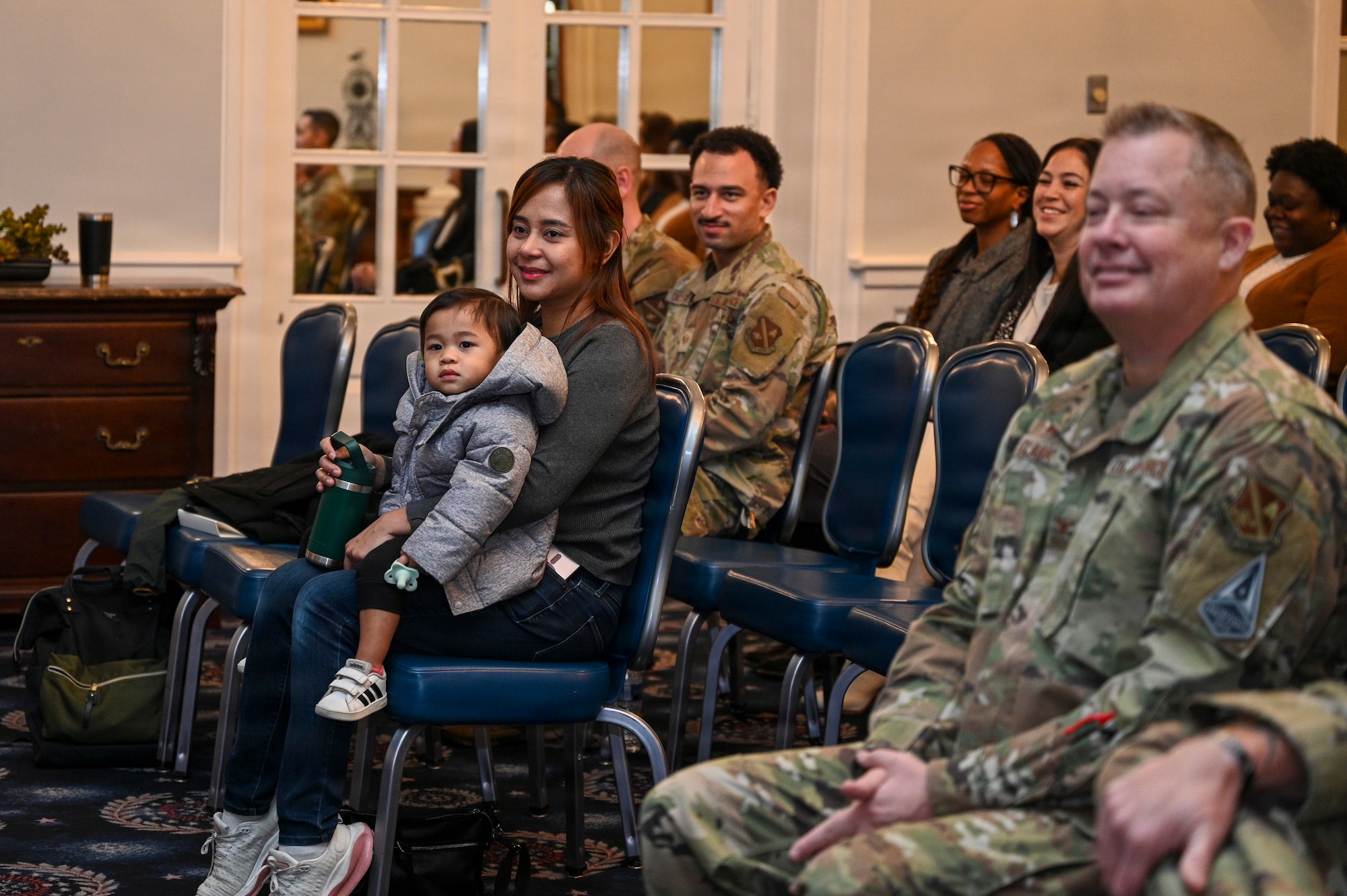 Angela and Carson Kido, wife and son of U.S. Air Force Maj. Brandon K. Kido, 11th Contracting Squadron incoming commander, observe the 11th CONS assumption of command ceremony at Joint Base Anacostia-Bolling, Washington, D.C., Jan. 23, 2026. Established in 2020 with the lead service transfer of JBAB from the U.S. Navy to the Air Force and the activation of the 11th Wing, the 11th CONS oversees the government purchase card program and manages purchasing and acquisition processes on JBAB. (U.S. Air Force photo by Airman 1st Class Shanel Toussaint)