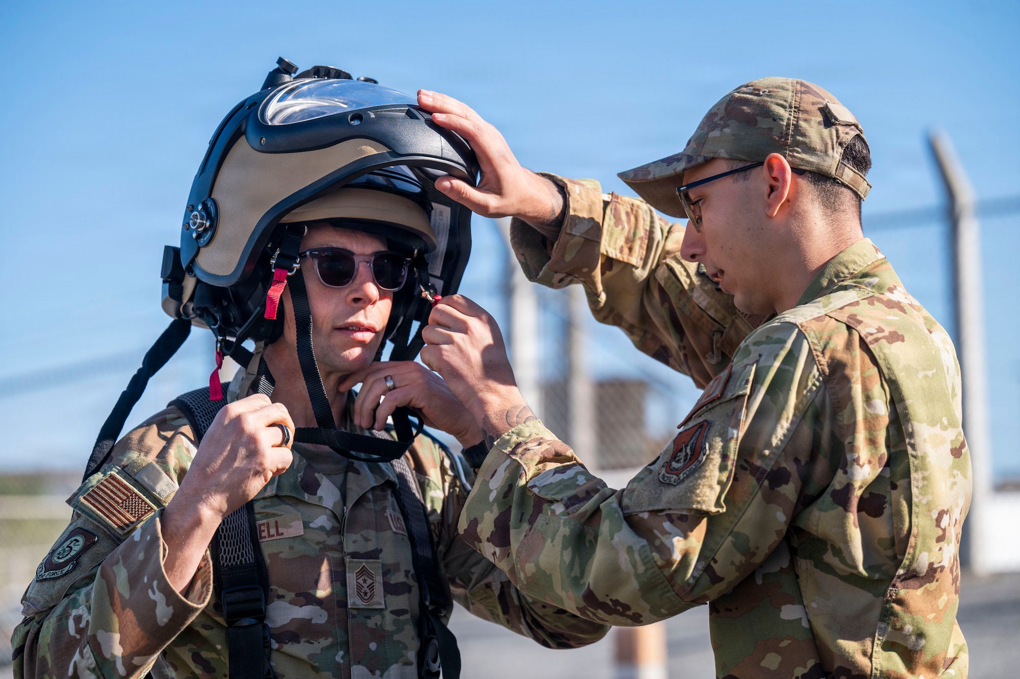 An  Explosive Ordinance Disposal team member assists the 5th Air Force Command Chief in donning a bomb suit at Kadena Air Base, Japan.