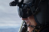 A man smiles while wearing a military aviation helmet