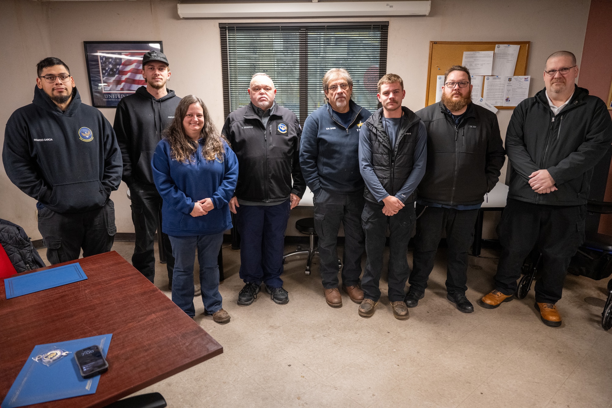 U.S. Air Force 97th Maintenance Squadron (MXS) maintainers stand alongside MXS leadership for a group photo at Altus Air Force Base, Oklahoma, Jan. 21, 2026. The maintainers were being recognized for their exemplary work repairing a tail-strike on a KC-135 Stratotanker aircraft, all receiving a Knuckle Buster award. (U.S. Air Force photo by Airman 1st Class Nathan Langston)