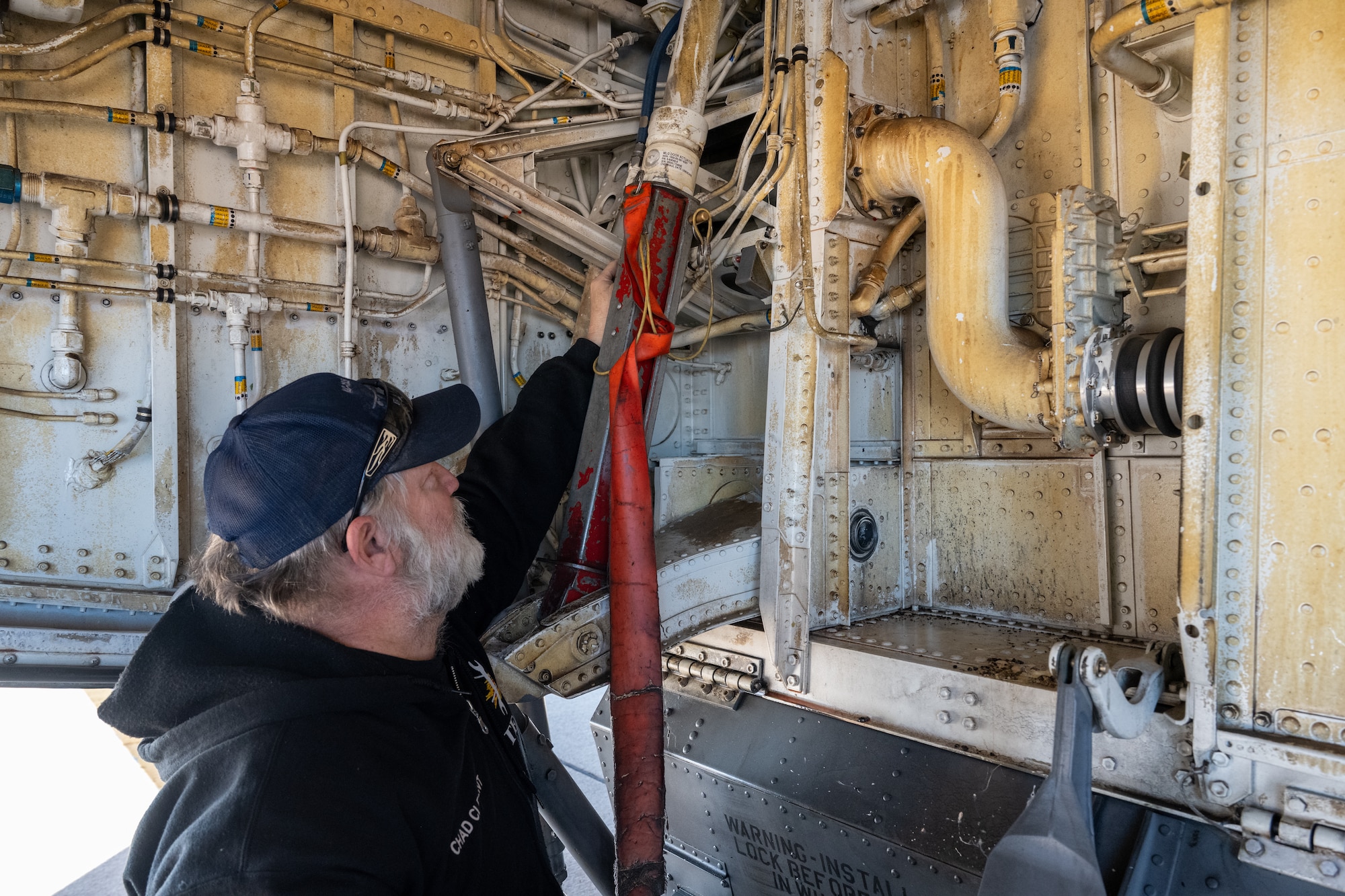 Chad Clement, U.S. Air Force 97th Aircraft Maintenance Squadron hydraulic specialist, visually inspects a KC-135 Stratotanker aircraft’s landing gear down lock at Altus Air Force Base, Oklahoma, Jan. 30, 2026. A downlock mechanically locks the landing gear in the fully extended position so it can’t retract and is safe to land on. (U.S. Air Force photo by Airman 1st Class Nathan Langston)