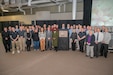 Several colleagues of Tania Perciaccante gather around a memorial plaque unveiled during a memorialization ceremony for Perciaccante.