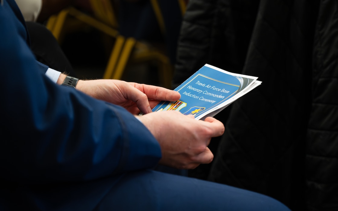 Man holds pamphlet during ceremony