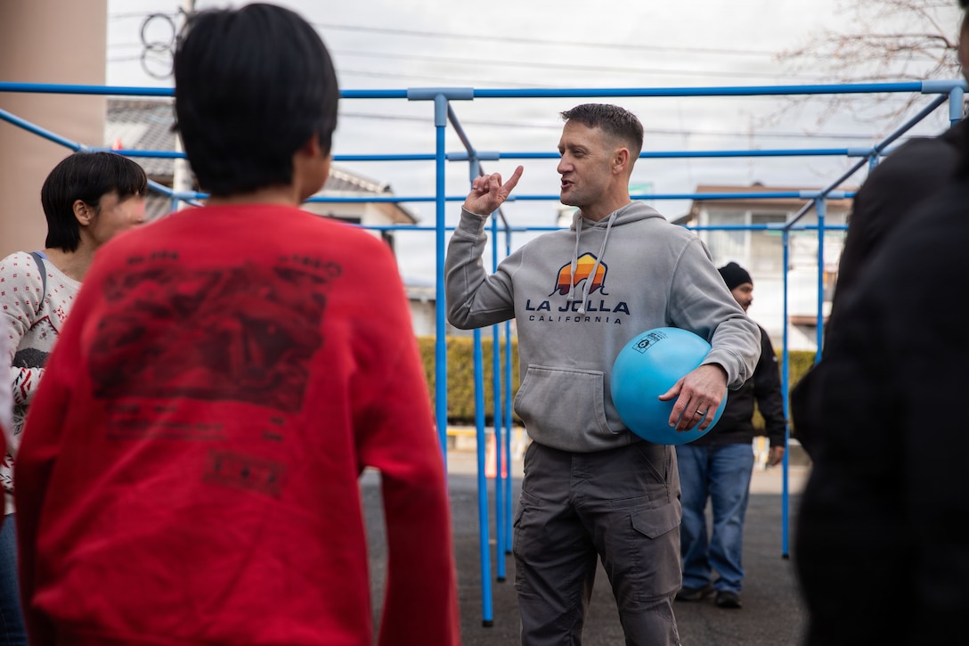 U.S. Navy Lt. Cmdr. Jarrod Johnson, the Marine Corps Air Station Iwakuni command chaplain and a native of Story City, Iowa, speaks to children from a local Iwakuni orphanage before a nine squares game during a community relations event at MCAS Iwakuni, Japan, Jan. 24, 2026. The station Chapel invited children from Kyorakuen and Hikarino Sono Orphanages to give them the opportunity to interact with base personnel and experience American Christmas traditions, fostering a healthy and positive relationship between the air station and local orphanages. (U.S. Marine Corps photo by Pfc. Kenneth Garcia)