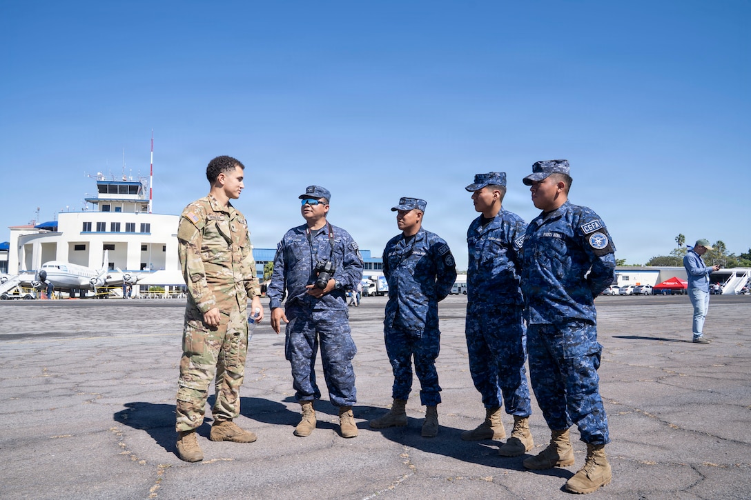 People in different military uniforms talk to one another