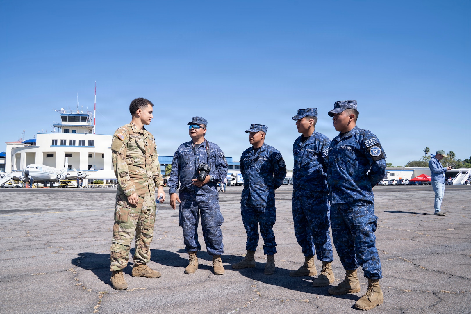 People in different military uniforms talk to one another
