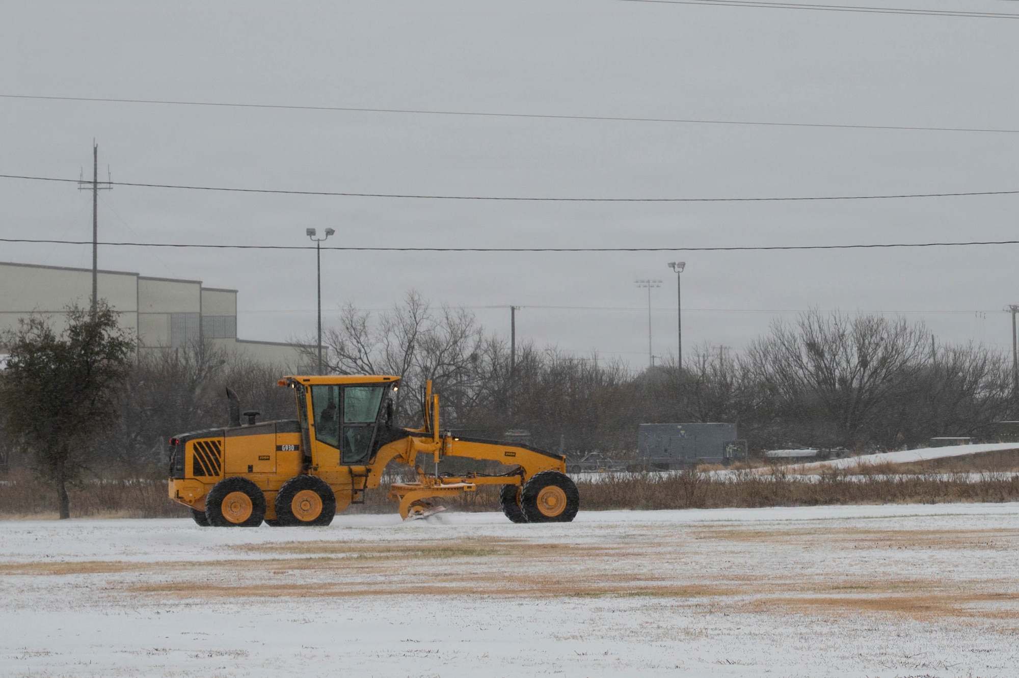 A U.S. Airman assigned to the 7th Civil Engineer Squadron removes ice during Winter Storm Fern at Dyess Air Force Base, Texas, Jan. 24, 2026. Historically, conditions like this at Dyess lead to waiting for solar melt rather than manual removal, but the 7th CES adapted operations to restore access and set conditions for airfield recovery during the 7th Bomb Wing’s Combat Readiness Exercise. (U.S. Air Force photo by Airman William Neal)
