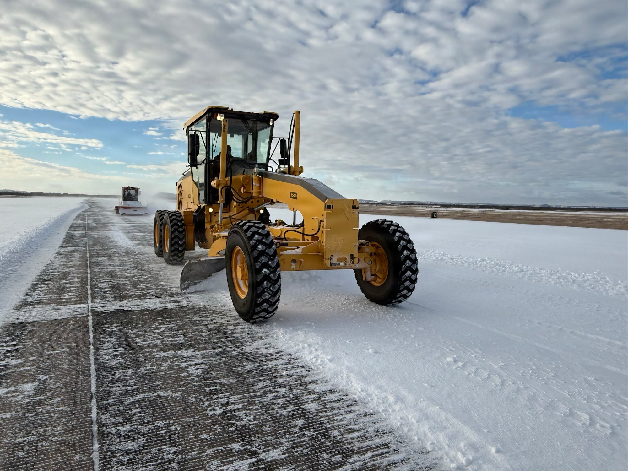 A U.S. Airman assigned to the 7th Civil Engineer Squadron removes ice from the runway during Winter Storm Fern at Dyess Air Force Base, Texas, Jan. 25, 2026. The storm struck on the second day of the 7th Bomb Wing’s Combat Readiness Exercise, depositing approximately three-quarters of an inch of ice and two inches of snow across the installation. The 7th CES reorganized operations to prepare infrastructure and accelerate timelines to reopen the airfield for safe flight operations. (Courtesy Photo)
