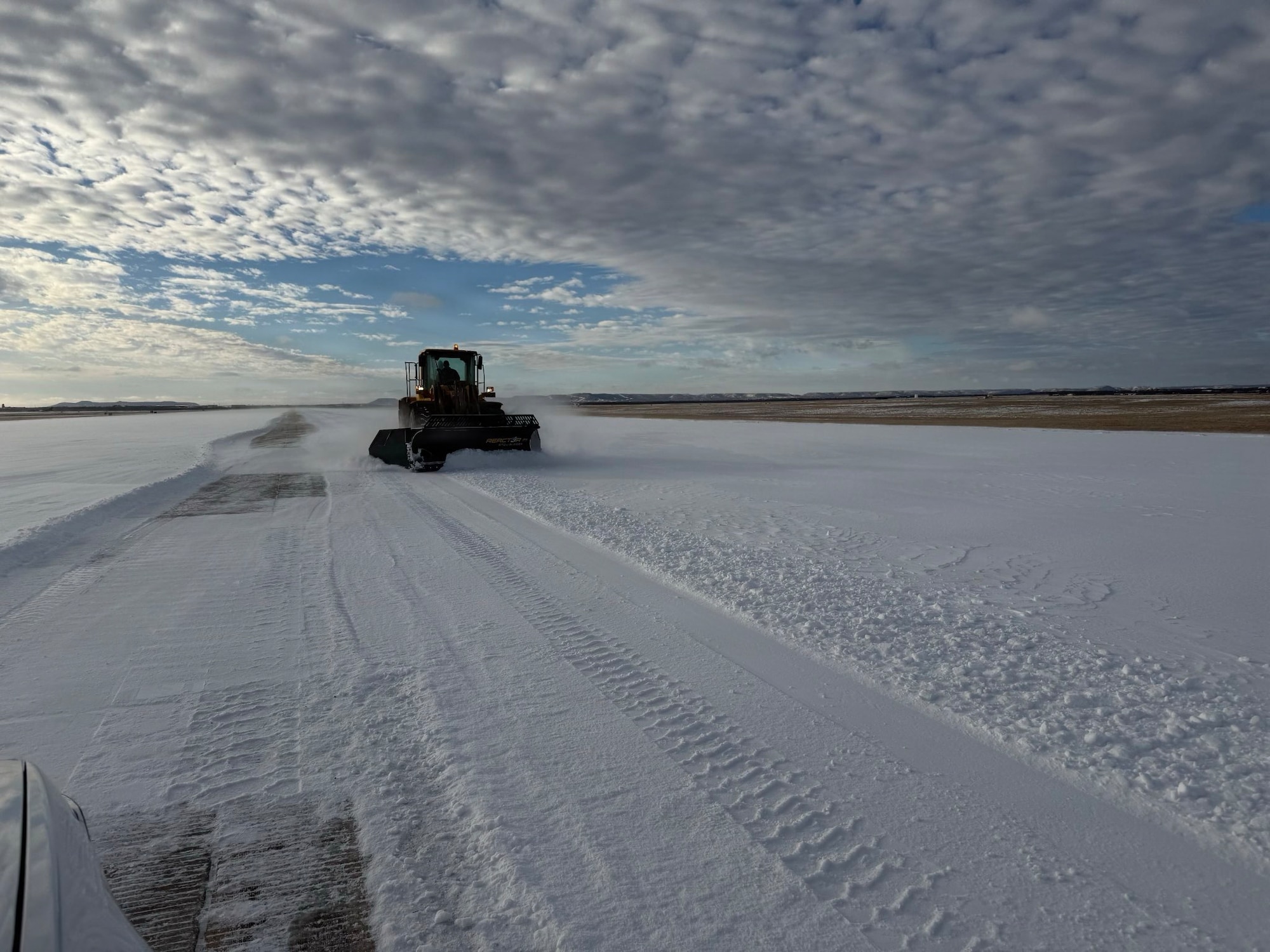 A U.S. Airman assigned to the 7th Civil Engineer Squadron removes ice from the runway during Winter Storm Fern at Dyess Air Force Base, Texas, Jan. 25, 2026. The storm struck on the second day of the 7th Bomb Wing’s Combat Readiness Exercise, depositing approximately three-quarters of an inch of ice and two inches of snow across the installation. The 7th CES reorganized operations to prepare infrastructure and accelerate timelines to reopen the airfield for safe flight operations. (Courtesy Photo)