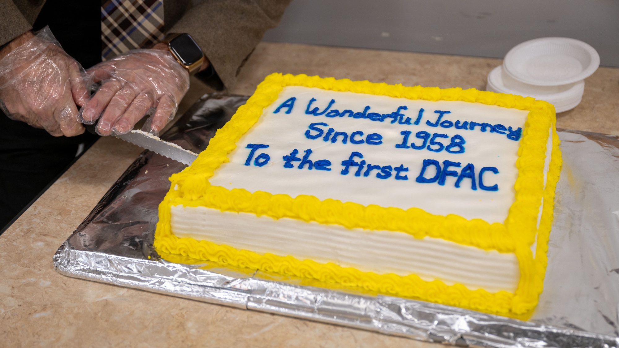Mr. Robert Clark, 51st Fighter Wing historian, slices cake at the Pacific House Dining Facility closing ceremony at Osan Air Base, Republic of Korea, Jan. 30, 2026. Airmen shared a final meal as the installation prepares for future investments that support readiness and quality of life. (U.S. Air Force photo by Senior Airman Rome Bowermaster)