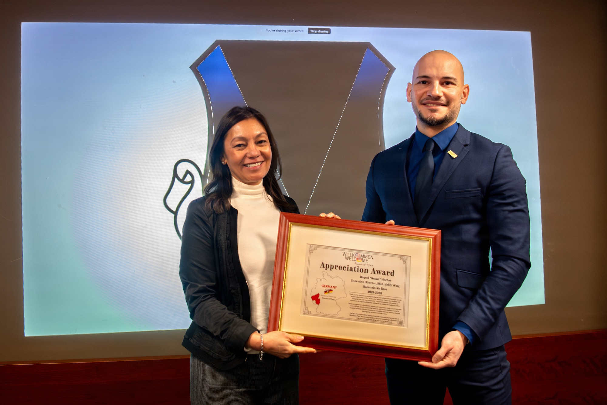 Mrs. Fischer receives an award by WiR! program manager during ceremony.