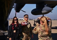 U.S. Air Force Staff Sgt. King Hey Leung from the 129th Maintenance Squadron, 129th Rescue Wing, and his wife, Crisly, shoot a social media clip during a Super Bowl LX military flyover outreach event, Feb. 5, on Moffett Air National Guard Base, Calif.