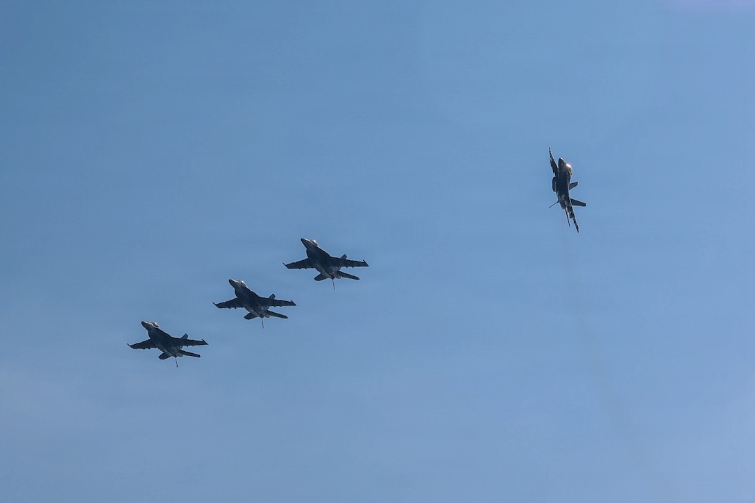 Four F/A-18E Super Hornets, attached to Strike Fighter Squadron (VFA) 14, fly above Nimitz-class aircraft carrier USS Abraham Lincoln (CVN 72) in the Arabian Sea, Jan. 30, 2026. Abraham Lincoln is deployed to the U.S. 5th Fleet area of operations to support maritime security and stability in the U.S. Central Command area of responsibility. (U.S. Navy photo by Mass Communication Specialist Seaman Hannah Tross)