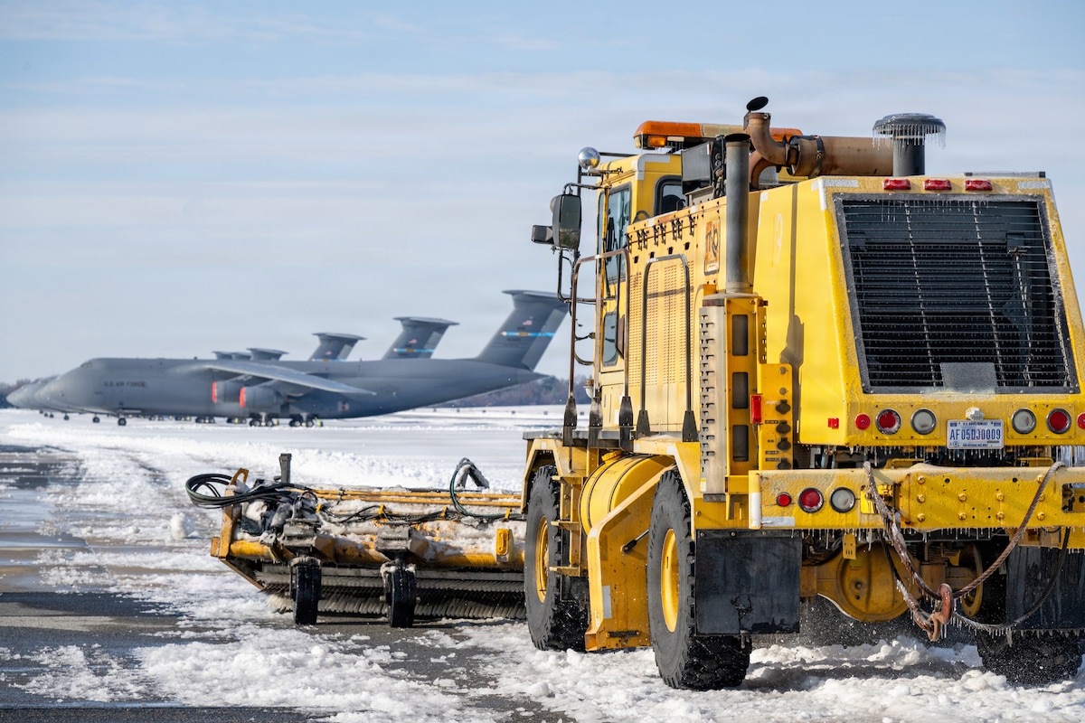 Airmen from the 436th Civil Engineer Squadron remove snow and ice from the flight line at Dover Air Force Base, Del., Jan. 26, 2026. The squadron conducted round-the-clock snow removal operations to prevent interruptions to the base's global airlift mission. (U.S. Air Force photo by Mauricio Campino)