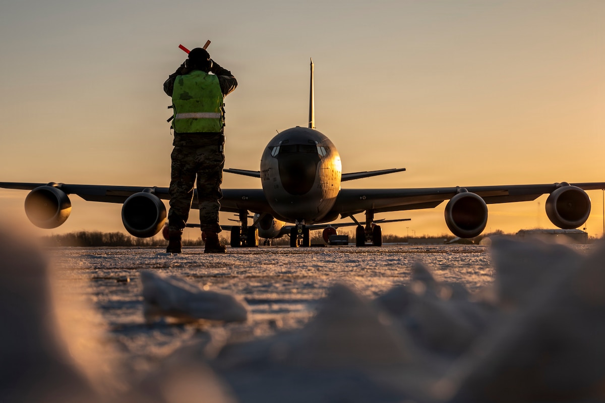 Master Sgt. Aaron Slupski, 121st Maintenance Group crew chief, prepares to marshal a KC-135 Stratotanker at Rickenbacker Air National Guard Base in Columbus, Ohio, Jan. 28, 2026. Maintainers and civil engineers with the 121st Air Refueling Wing reestablished flight line operations after Winter Storm Fran brought over 10 inches of snow and single-digit temperatures to the area. (U.S. Air National Guard photo by Ralph Branson)