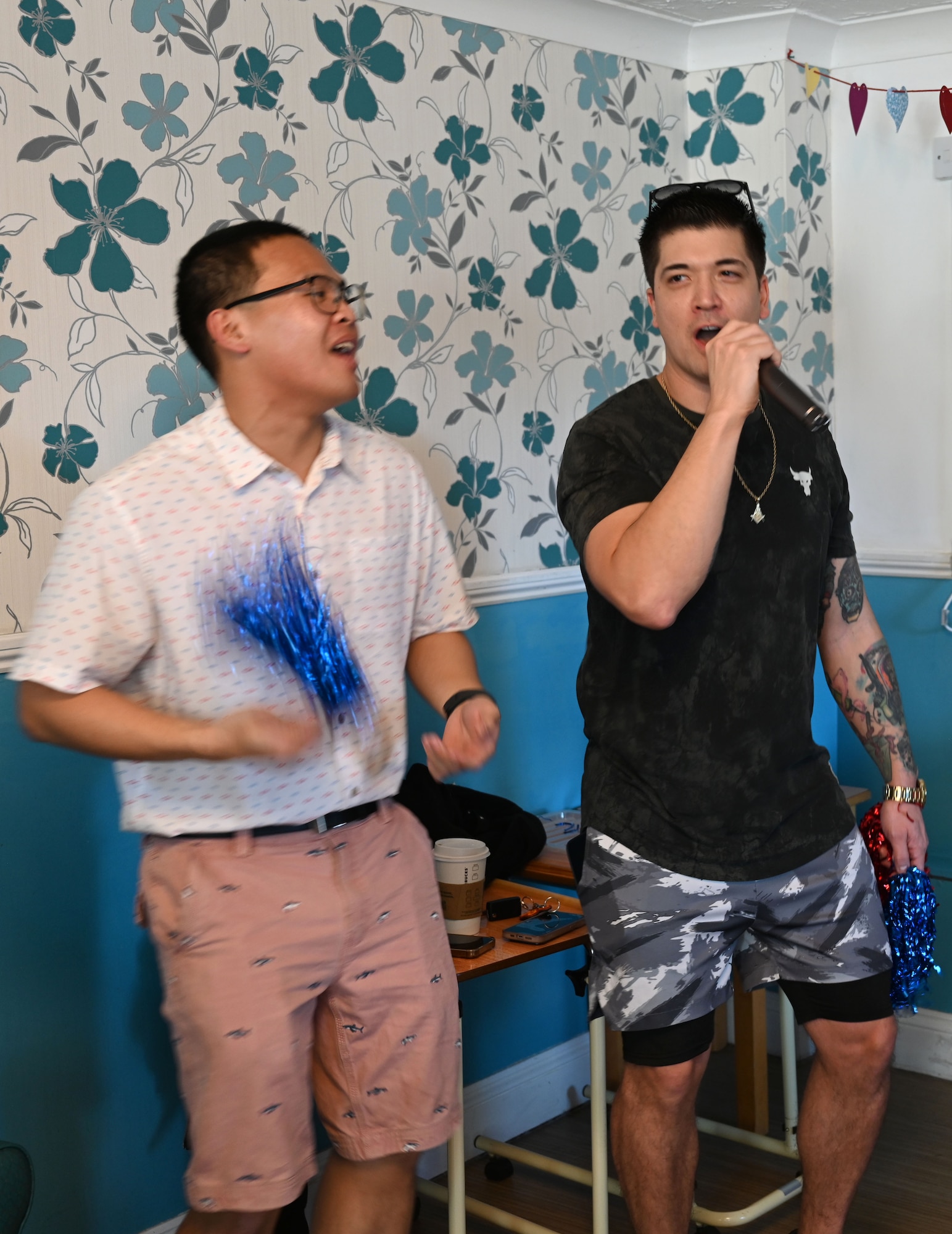 U.S. Air Force Airman 1st Class Julius Del Rosario, left, 100th Communications Squadron, and Master Sgt. Alexander Barrett, 100th Civil Engineer Squadron, sing karaoke for residents at Mabbs Hall Care Home, Mildenhall, England, Jan. 28, 2026. Airmen with the RAF Mildenhall Top 3, 100th CES and 100th CS  visited the local care home to spend time with and entertain residents. Team Mildenhall Airmen regularly volunteer within the local area to strengthen partnerships and build community relations. (U.S. Air Force photo by Karen Abeyasekere)