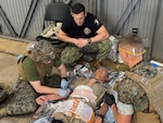 Lt. Cmdr. Ian Eisenhauer and Lt. Cmdr. Ronald Fenton, emergency medicine physicians assigned to II Marine Expeditionary Force (II MEF), perform a simulated autologous fresh whole blood transfusion on Capt. Andrew Lin, commanding officer of Navy Medicine Readiness and Training Command (NMRTC) Fort Belvoir, while Lt. Cmdr. Josh Kotler, command program director, evaluates the team during a Joint Trauma System (JTS) Valkyrie Course, Jan. 23, 2026. The training prepares teams to run Emergency Fresh Whole Blood Transfusion (EFWBT) programs in large-scale combat and austere environments. (U.S. Navy photo by Hospital Corpsman 3rd Class Briana Baxter)