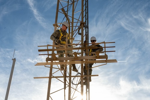 U.S. Air Force Tech. Sgt. Keenan Herlocker, Air Forces Central Deployed Regional Maintenance Center noncommissioned officer in charge, and Staff Sgt. Jessica Ayala, AFCENT DRMC production control noncommissioned officer in charge, adjust antennae heights on a glide slope.