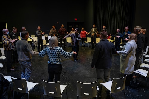 Group of professionals standing in a circle and learning to conduct.