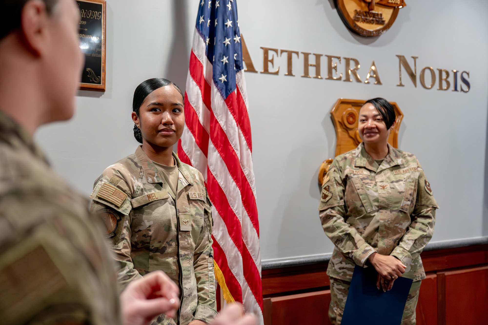 U.S. Air Force Airman Destiny Mel, 42d Security Forces Squadron entry controller, and Col. Shamekia Toliver, 42d Air Base Wing commander, listen as Tech. Sgt. Sydnie Colbert, 42d SFS flight chief, speaks at Maxwell Air Force Base, Alabama, Feb. 4, 2026.