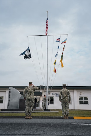 Commander John Frank (left) Commanding Officer of Naval Mobile Construction Battalion (NMCB) 4, salutes as the battalion flag is lowered during the Relief-in-Place / Transfer-of-Authority (RIPTOA) ceremony from NMCB 4 to NMCB 11 on Camp Shields, Okinawa, Japan, Feb. 02, 2026.