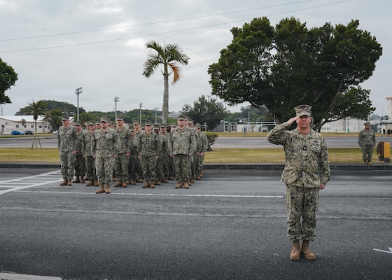 Captain James Angerman (right) Commanding Officer of Naval Mobile Construction Battalion (NMCB) 11, salutes as the battalion flag is raised during the Relief-in-Place / Transfer-of-Authority (RIPTOA) ceremony from NMCB 4 to NMCB 11 on Camp Shields, Okinawa, Japan, Feb. 02, 2026.