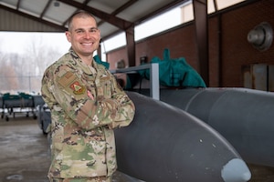 Man poses in front of fuel tank