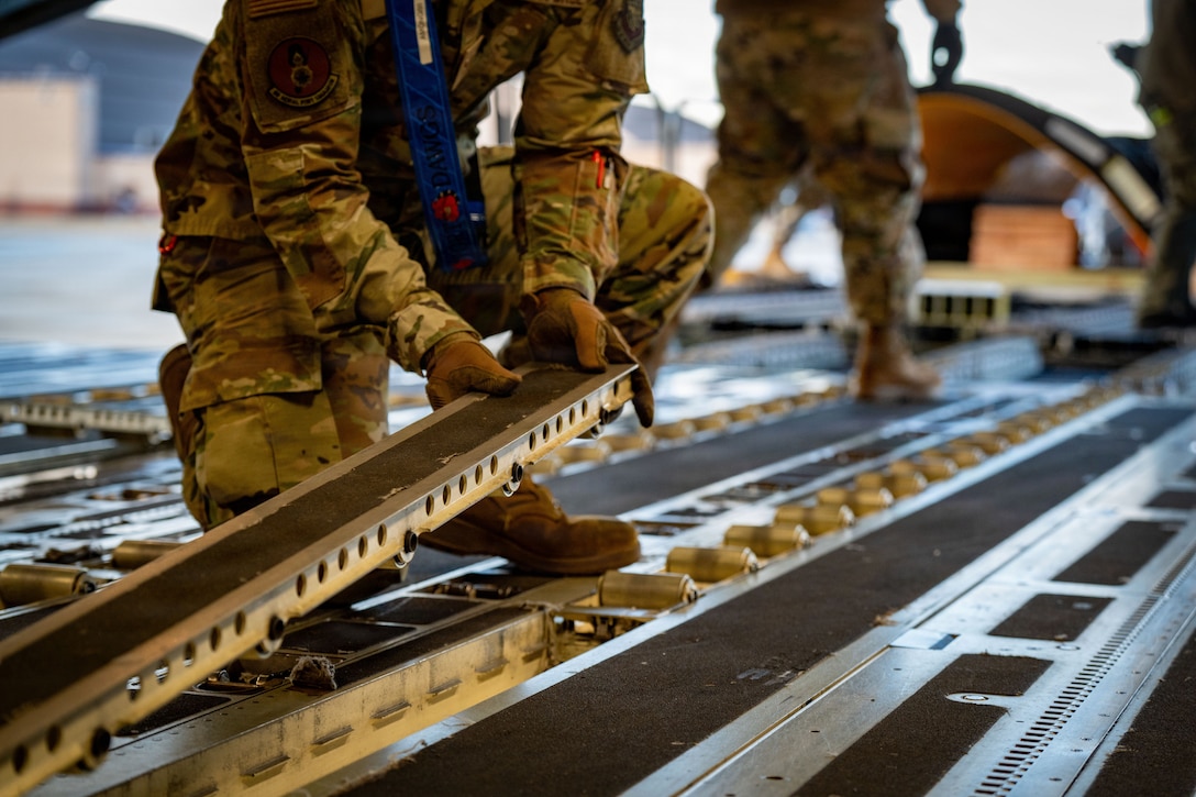 U.S. Air Force Airman 1st Class Alexander Monge, 89th Aerial Port Squadron aircraft services journeyman, reconfigures a C-17 Globemaster III aircraft to unload heavy snow removal equipment at Joint Base Andrews, Md., Jan. 23, 2026. Air Mobility Command mobilized mission-ready Airmen and specialized equipment in support of winter weather preparedness efforts to ensure “America’s Airfield” remains operational amid historic severe weather impacts. (U.S. Air Force photo by 1st Lt. Alexis Kula)