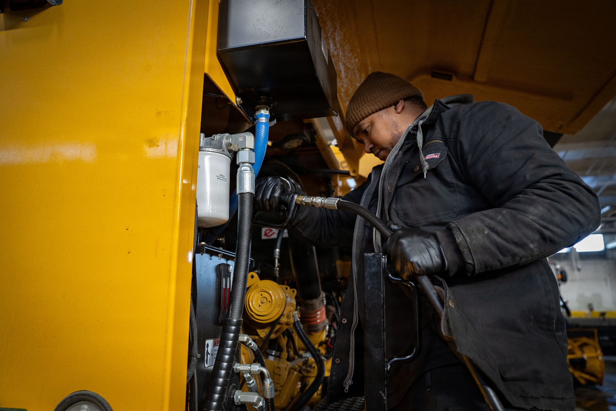 U.S. Air Force Staff Sgt. Owen Gill, 6th Logistics Readiness Squadron vehicle maintenance supervisor, MacDill Air Force Base, Fl., refills hydraulic fluid on a snowplow at Joint Base Andrews, Md., Jan. 29, 2026. Air Mobility Command mobilized mission-ready Airmen and specialized equipment in support of winter weather preparedness efforts to ensure “America’s Airfield” remained operational amid historic severe weather impacts. (U.S. Air Force photo by 1st Lt. Alexis Kula)