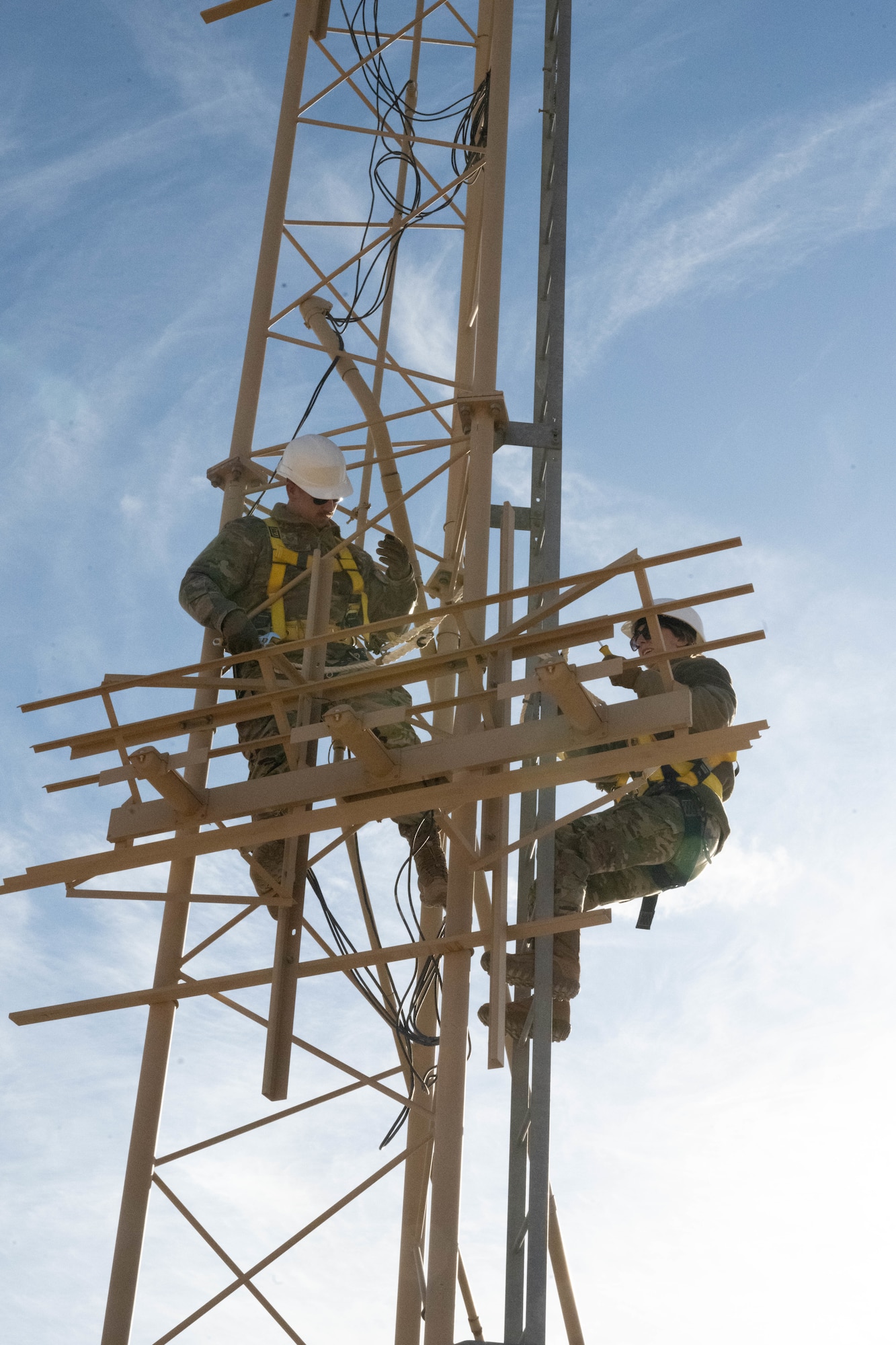 U.S. Air Force Tech. Sgt. Keenan Herlocker, Air Forces Central Deployed Regional Maintenance Center noncommissioned officer in charge, left, and Staff Sgt. Jessica Ayala, AFCENT DRMC production control noncommissioned officer in charge, right, adjust antennae heights on a glide slope in the U.S. Central Command area of responsibility Feb. 5, 2026. The system gives pilots reliable guidance to established touchdown points when the runway is not visually acquired. (U.S. Air Force photo by Senior Airman Kari Degraffenreed)