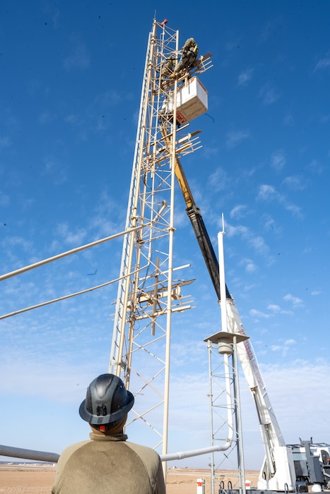 U.S. Air Force Senior Airman Gregory Curry, 332nd Expeditionary Civil Engineer Squadron electrical journeyman, supervises Airmen from the Air Forces Central Deployed Regional Maintenance Center while they adjust antennae heights on a glide slope in the U.S. Central Command area of responsibility, Jan. 31, 2026. The work required coordination between the 332nd ECES and Airmen assigned to the DRMC to support flight inspection and system certification. (U.S. Air Force photo by Senior Airman Kari Degraffenreed)