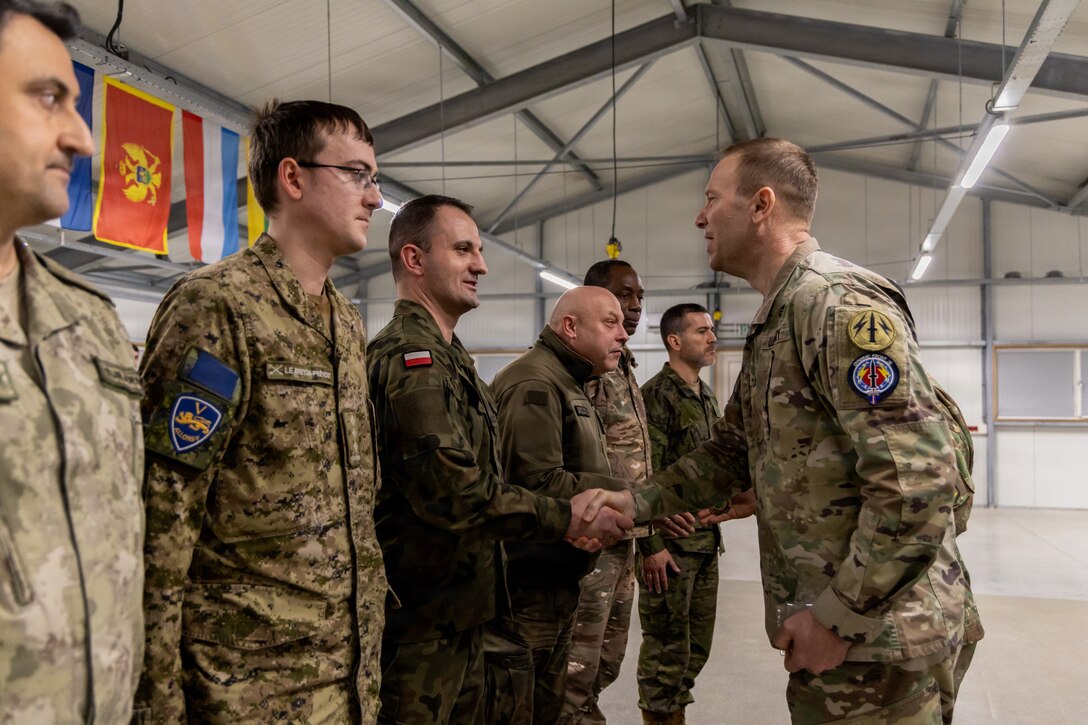 U.S. Army Col. Jeffrey Fuller, assigned to Multi-Domain Command Europe, presents a coin of excellence to a Polish Armed Forces Soldier during a recognition ceremony for Dynamic Front 26, Feb. 05, 2026, in Cincu, Romania.