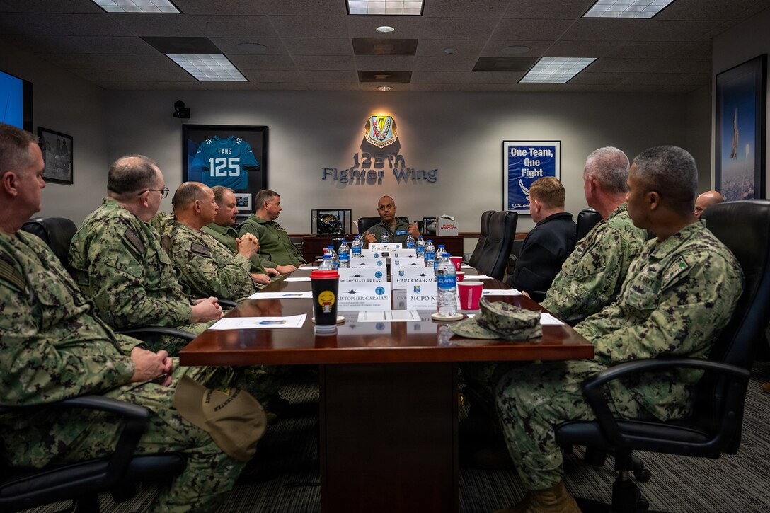 U.S. Air Force Col. Mansour Elhihi, center, commander of the Florida Air National Guard’s 125th Fighter Wing, briefs local military leaders during a tour at Jacksonville Air National Guard Base, Florida, Feb. 6, 2026. Inviting Jacksonville’s military leaders from Blount Island Command, Naval Air Station Jacksonville, Naval Submarine Base Kings Bay, Naval Station Mayport, and Navy Medical Readiness and Training Command to the Florida Air National Guard’s 125th Fighter Wing for a briefing on its missions and F-35A Lightning II aircraft fosters inter-service partnerships and strengthens relationships with the local military community. (U.S. Air National Guard photo by Tech. Sgt. Marissa Welker)