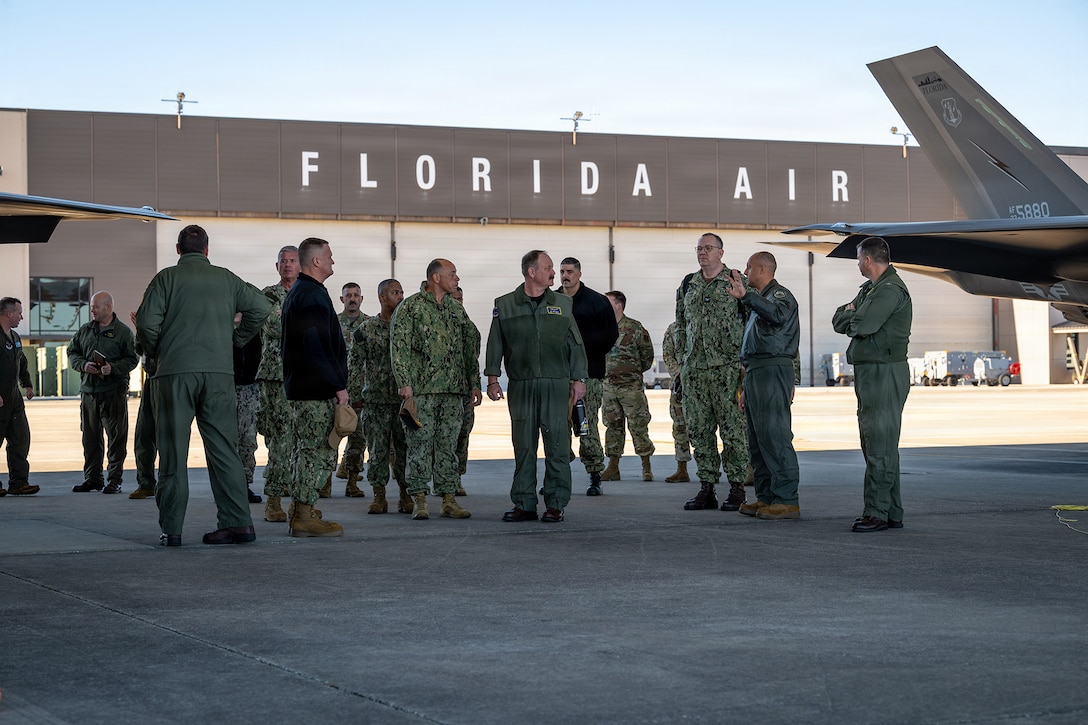 U.S. Air Force Col. Mansour Elhihi, right, commander of the Florida Air National Guard’s 125th Fighter Wing, briefs local military leaders during a tour at Jacksonville Air National Guard Base, Florida, Feb. 6, 2026. Inviting Jacksonville’s military leaders from Blount Island Command, Naval Air Station Jacksonville, Naval Submarine Base Kings Bay, Naval Station Mayport, and Navy Medical Readiness and Training Command to the Florida Air National Guard’s 125th Fighter Wing for a briefing on its missions and F-35A Lightning II aircraft fosters inter-service partnerships and strengthens relationships with the local military community. (U.S. Air National Guard photo by Tech. Sgt. Marissa Welker) (This photo was altered for security purposes by blurring out identification badges.)