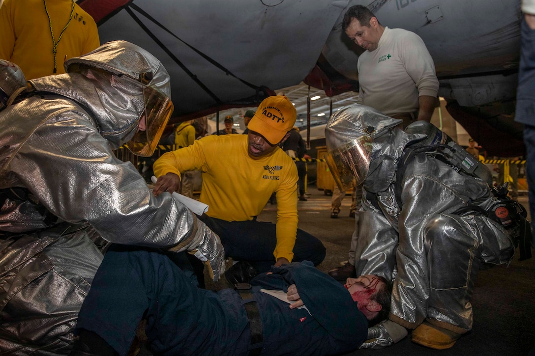 U.S. Sailors participate in a mass casualty drill in the hangar bay of Nimitz-class aircraft carrier USS Abraham Lincoln (CVN 72) in the Arabian Sea, Feb. 5, 2026. Abraham Lincoln is deployed to the U.S. 5th Fleet area of operations to support maritime security and stability in the U.S. Central Command area of responsibility. (U.S. Navy photo by Mass Communication Specialist Seaman Apprentice Cesar Zavala)