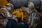 U.S. Sailors participate in a mass casualty drill in the hangar bay of Nimitz-class aircraft carrier USS Abraham Lincoln (CVN 72) in the Arabian Sea, Feb. 5, 2026. Abraham Lincoln is deployed to the U.S. 5th Fleet area of operations to support maritime security and stability in the U.S. Central Command area of responsibility. (U.S. Navy photo by Mass Communication Specialist Seaman Apprentice Cesar Zavala)