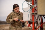 U.S. Air Force Airman Meaghan Marques, 502d Operations Support Squadron radar airfield and weather systems technician, tightens panel screws on a fixed base weather observation system, specifically an AN/FMQ-19, at Joint Base San Antonio–Lackland, Texas, Jan. 30, 2025. The system collects and transmits weather data used to inform airfield conditions and operational decision-making. (U.S. Air Force photo by Jonathan R. Mallard)