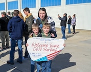 Eight-year-old Tommy Burbach and 7-year-old Danny Burbach hold a sign welcoming home their father, Illinois Army National Guard Chief Warrant Officer 2 Chris Burbach with their mother, Sam Burbach.