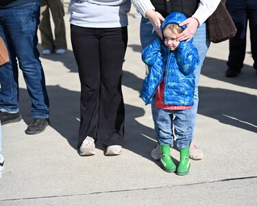 Three-year-old Maverick Ricketts holds his ears in the cold as the airplane carrying his father, Illinois Army National Guard Cpl. Briar Ricketts, lands in Springfield.