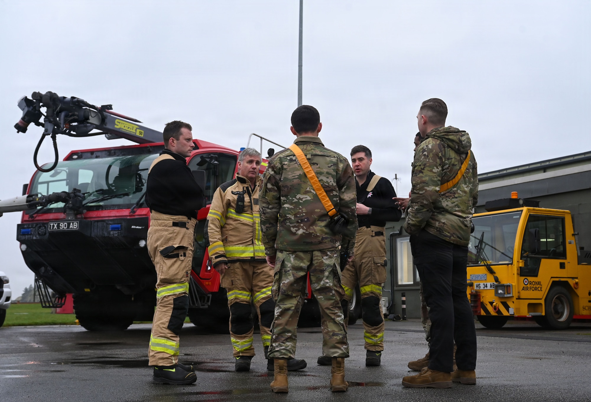 U.S. Airmen from the 48th Fighter Wing discuss airfield operations with Royal Air Force personnel.