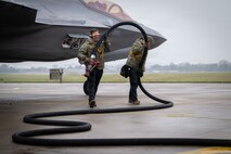 Photo of two U.S. Service members conducting hot pit refueling.