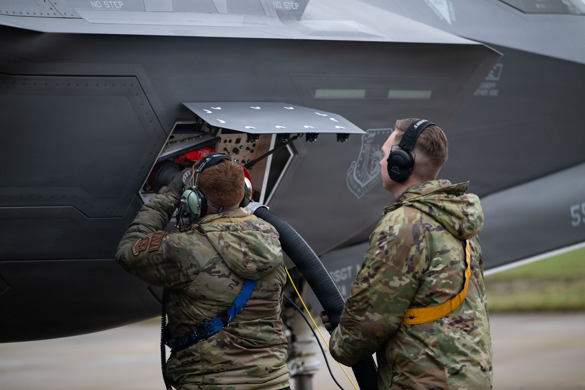 U.S. Air Force Airman 1st Class Logan Gillmer, 492nd Fighter Generation Squadron avionics technician, and Staff Sgt. Evan Schneider, 493rd FGS dedicated crew chief, conduct hot-pit operations on an F-35A Lightning II aircraft.