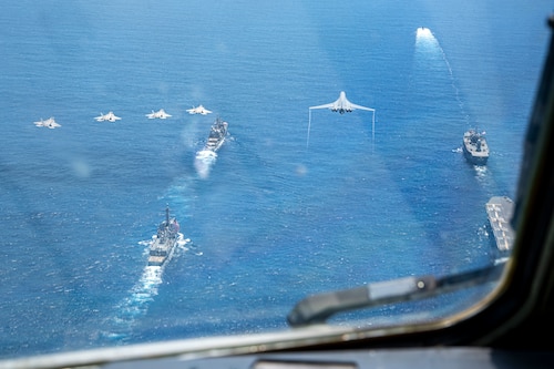 A U.S. Air Force B-1B Lancer assigned to the 37th Bomb Squadron and U.S. Air Force F-22 Raptors assigned to the 90th Fighter Squadron fly in formation above U.S. Navy and Japan Maritime Self-Defense Force ships in the Pacific Ocean in support of Valiant Shield 2024, June 7, 2024. Exercises such as Valiant Shield allow the Indo-Pacific Command Joint Forces the opportunity to integrate forces from all branches of service and with our allies to conduct precise, lethal, and overwhelming multi-axis, multi-domain effects that demonstrate the strength and versatility of the Joint Force and our commitment to a free and open Indo-Pacific. (U.S. Air Force photo by Senior Airman Keegan Putman)