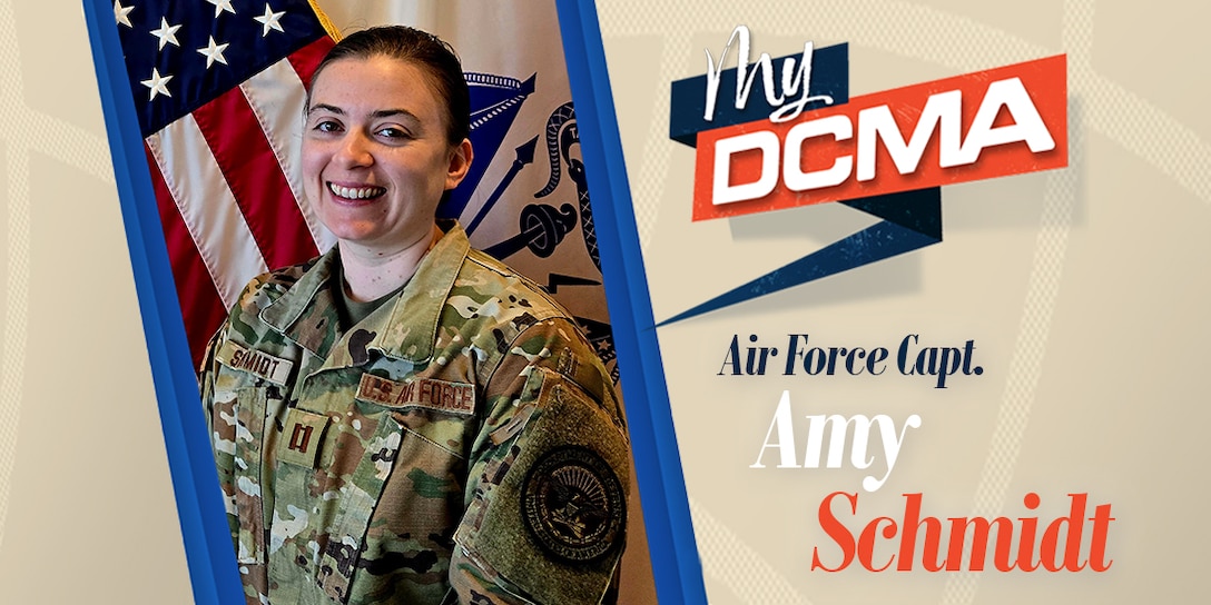 A smiling Amy Schmidt wears a military camouflage uniform while standing by the American flag