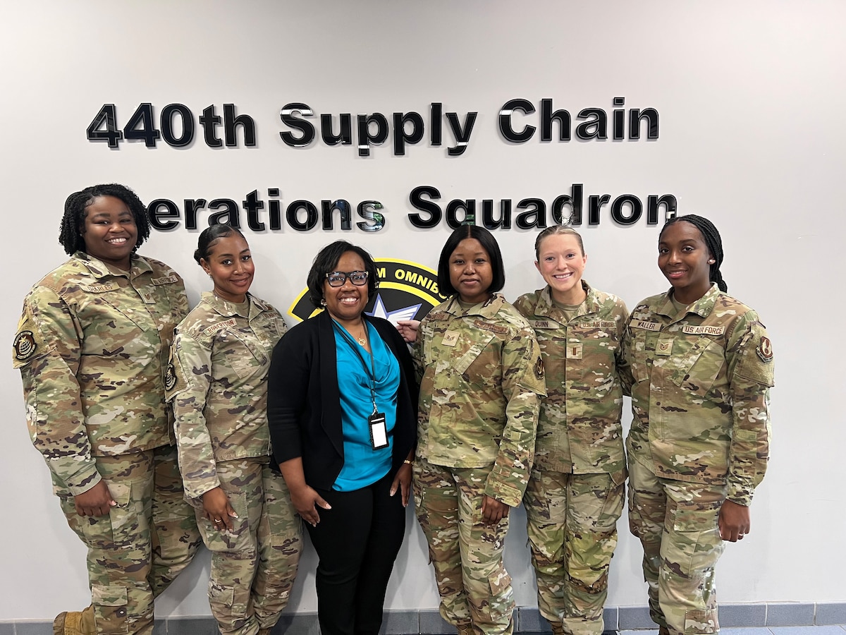 A logo and a group of military personnel.