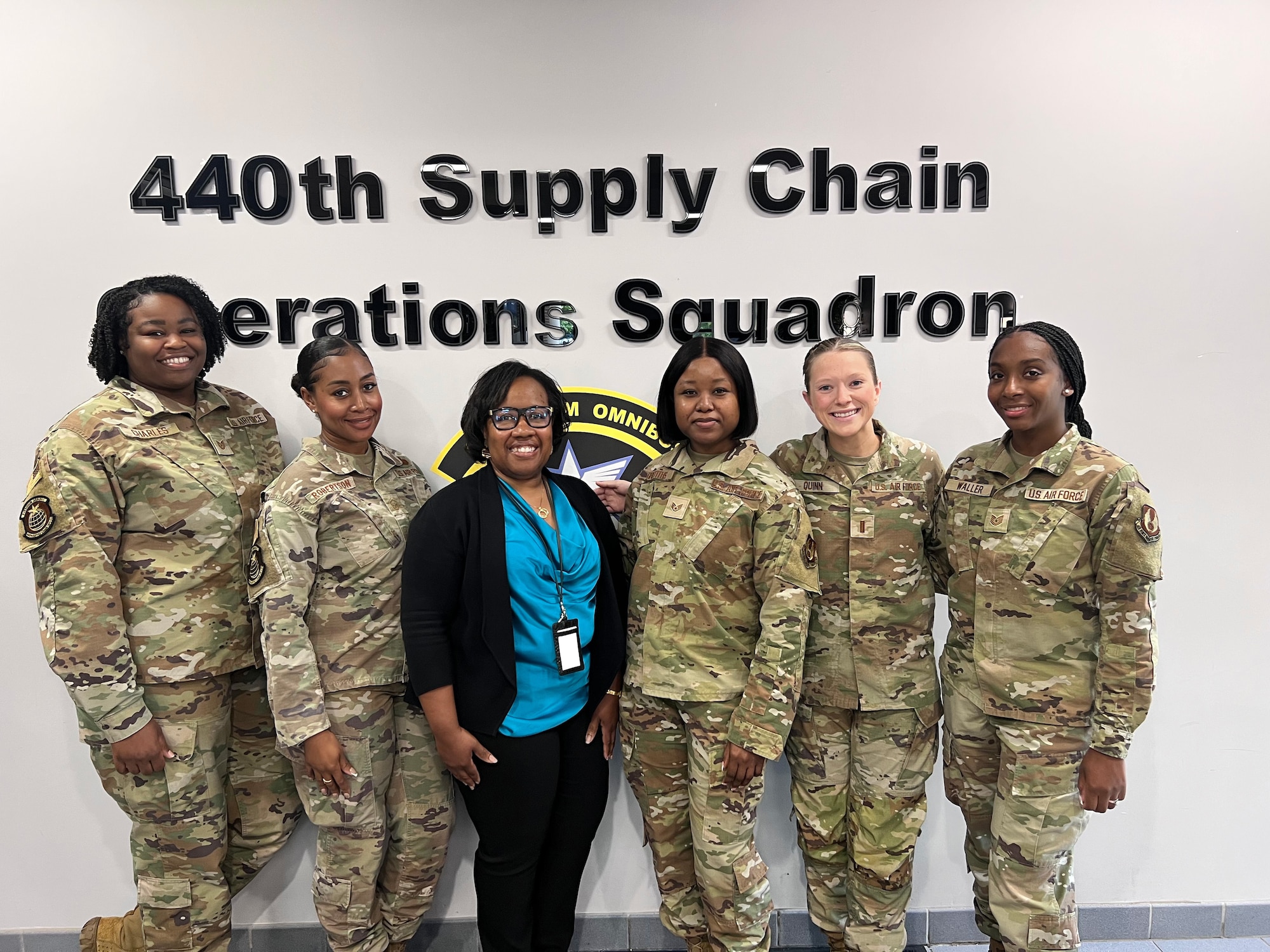 A logo and a group of military personnel.