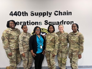 A logo and a group of military personnel.